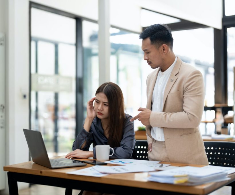 Asian team leader correcting offended employee at work. Mentor conflicts with student. Manager