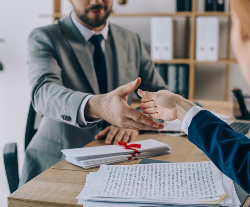 partial view of lawyers shaking hands on meeting in office